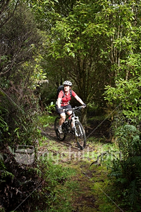 A lady mountain biker; on a bush ride with a daypack.