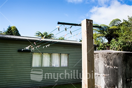 A typical holiday setting; clothes line attached to the shed accomodation and a concrete tank for water storage.