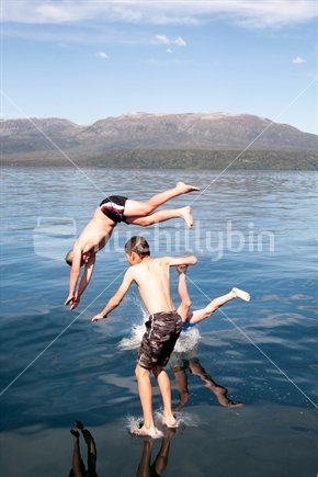 Kids having fun jumping from a boat into Lake Tarawera