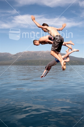 Kids having fun jumping from a boat into Lake Tarawera
