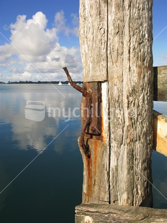 Wooden pylon on old wharf with rusty cleat