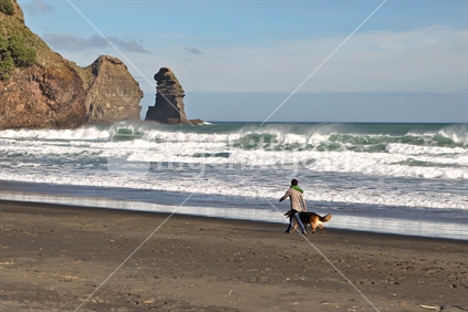 Woman and Dog Exercise near Surf in New Zealand
