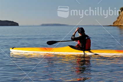 Recreational canoeist in early morning light on calm water