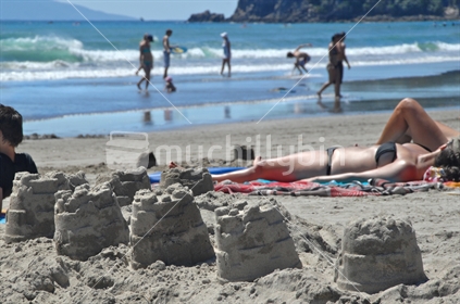 Sand castles on the beach with people - summer scene
