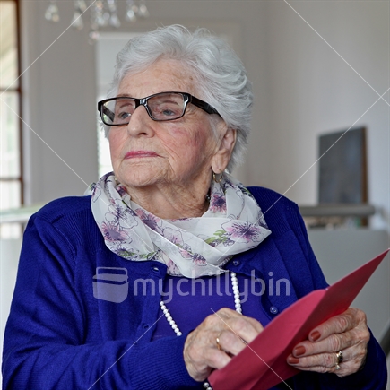 Elderly woman, opens her birthday card