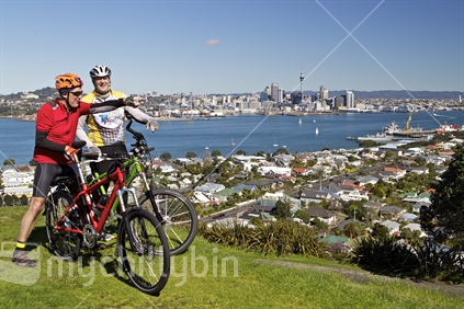 Two blokes with bikes looking across scene from Mt Victoria, Devonport