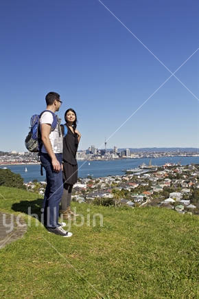 A couple on top of Mt Victoria, Devonport, Auckland with panoramic Auckland scenery