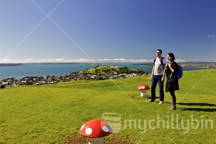 A couple on top of Mt Victoria, Devonport, Auckland with panoramic Auckland scenery