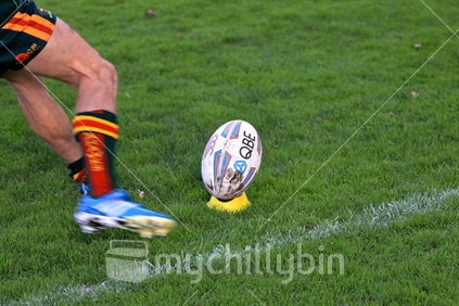 Rugby - the national sport: Place kicker about to contact ball on the kicking tee (some motion blur)