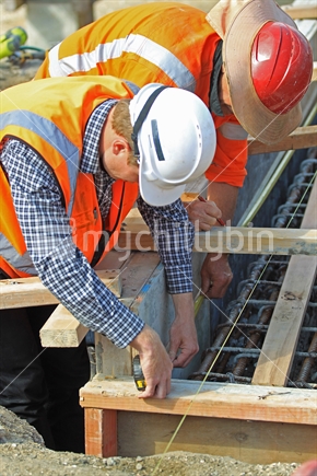 Men at work constructing formwork, on a building construction site
