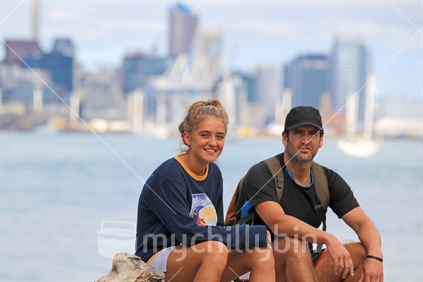Dad and teen daughter on beach with Auckland city background