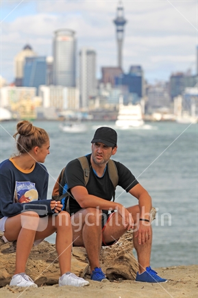Dad and Teen daughter on beach with Auckland city background