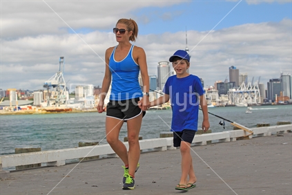 Mother and son - wharf walk with Auckland city background
