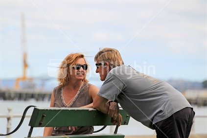 Couple talking on bench outdoors