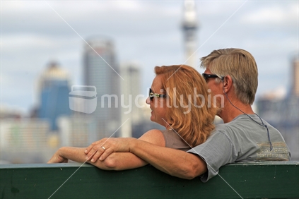Closeup couple seated with Auckland CBD in background