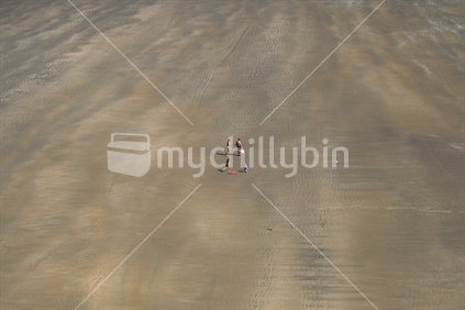 Elevated view of family walking on wet sand beach