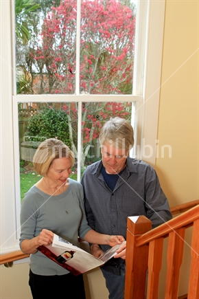 Senior couple on stair against window