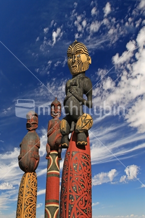 Maori Carvings - Pouwhenua colourful against blue sky