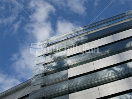 Auckland blue clouds and sky blend with building's mirrored surface.