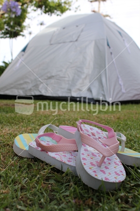 Child's jandals infront of the tent during a summer camping trip