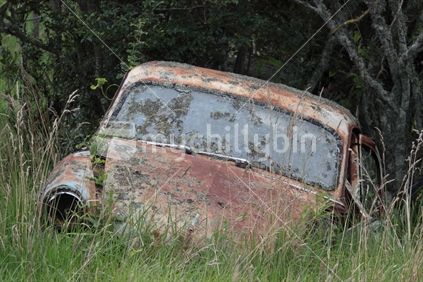 Old abandoned car in paddock, closeup.