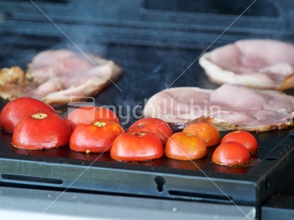Tomato and bacon on barbecue hotplate