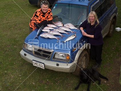 A good catch of New Zealand snapper and kahawai by husband and wife team (and dog).