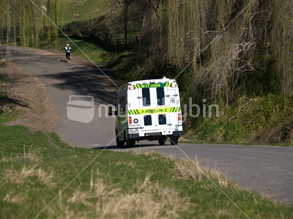 An ambulance on a rural road during a marathon road race
