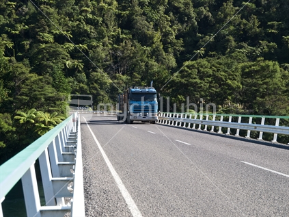 A logging truck on the bridge over the lower reaches of the Motu River, Bay of Plenty, New Zealand