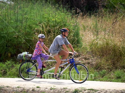Man and girl cycling on a lime sand cycleway near Haumoana, Hawke''s Bay.