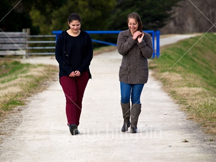 Two young women walking and talking on a lime sand track in Hawke's Bay
