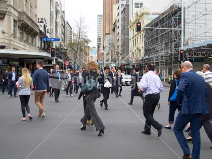 Pedestrians crossing the intersection of Customs Street West and Queen Street at lunchtime in Auckland