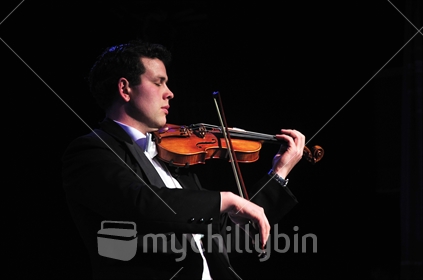 Violinist with eyes closed performing in live concert