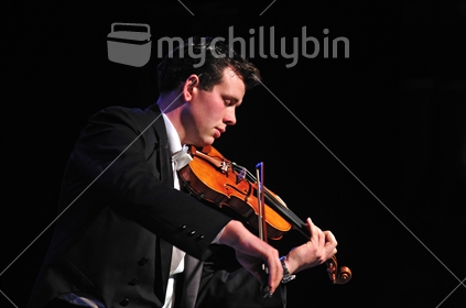 New Zealand violinist with closed eyes performing in live concert