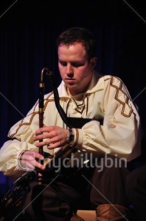 Man playing the irish bagpipes in live New Zealand performance