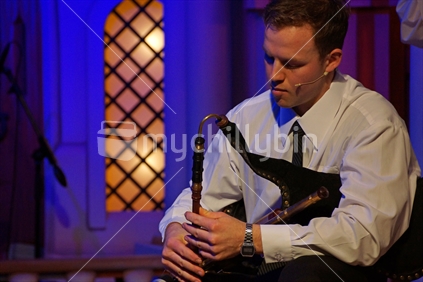 Man playing the irish bagpipes in live performance