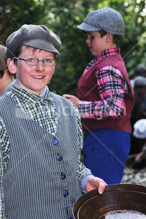Schoolboy dressed in period costume panning for gold at Shantytown, Westland, on a school outing to learn about the gold rushes.