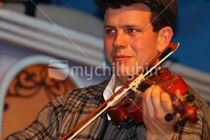 Mature man in hillbilly costume  playing violin