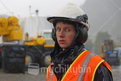 Portrait of man working at a construction site a cold wet day, Westland