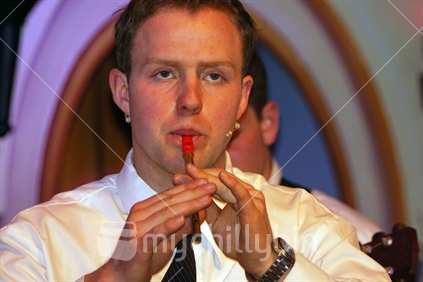 Band member playing a tin whistle in live performance
