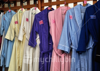 Examples of different sized dressing gowns hanging up in a sewing room