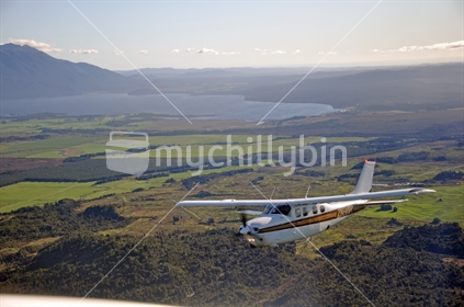 Cessna 210 pressurised passenger aeroplane above Lake Brunner, New Zealand