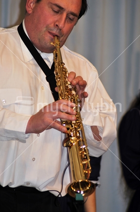 Man playing soprano saxophone in live performance