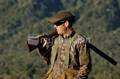 Hunter carries his shotgun while looking for game birds