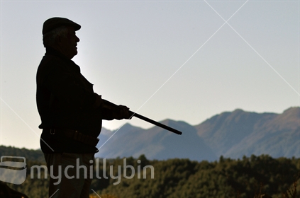 Silhouette of hunter at the ready with his shotgun