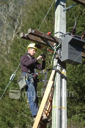 Electrician secures wires on power pole (focus on pole timber cross bar)