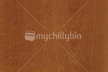 background of wood grain from Knightia excelsa, commonly called rewarewa, an evergreen tree endemic to the low elevation forests of New Zealand