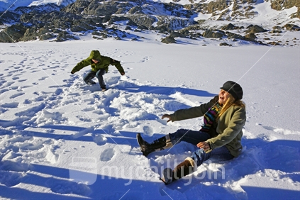 Tourists play in the snow on the neve of the Franz Josef Glacier during a helicopter visit in the Southern Alps