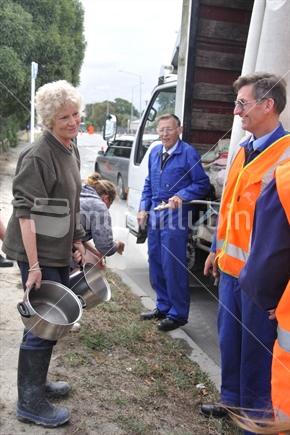 Volunteers chat with a woman collecting water after the 6.4 earthquake in Christchurch, 22-2-2011, (raised ISO)