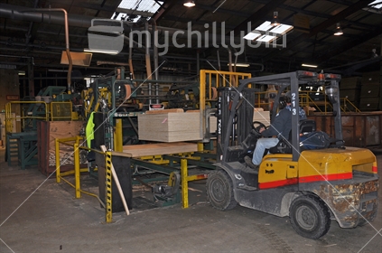 Forklift carries a pallet of completed plywood at the factory